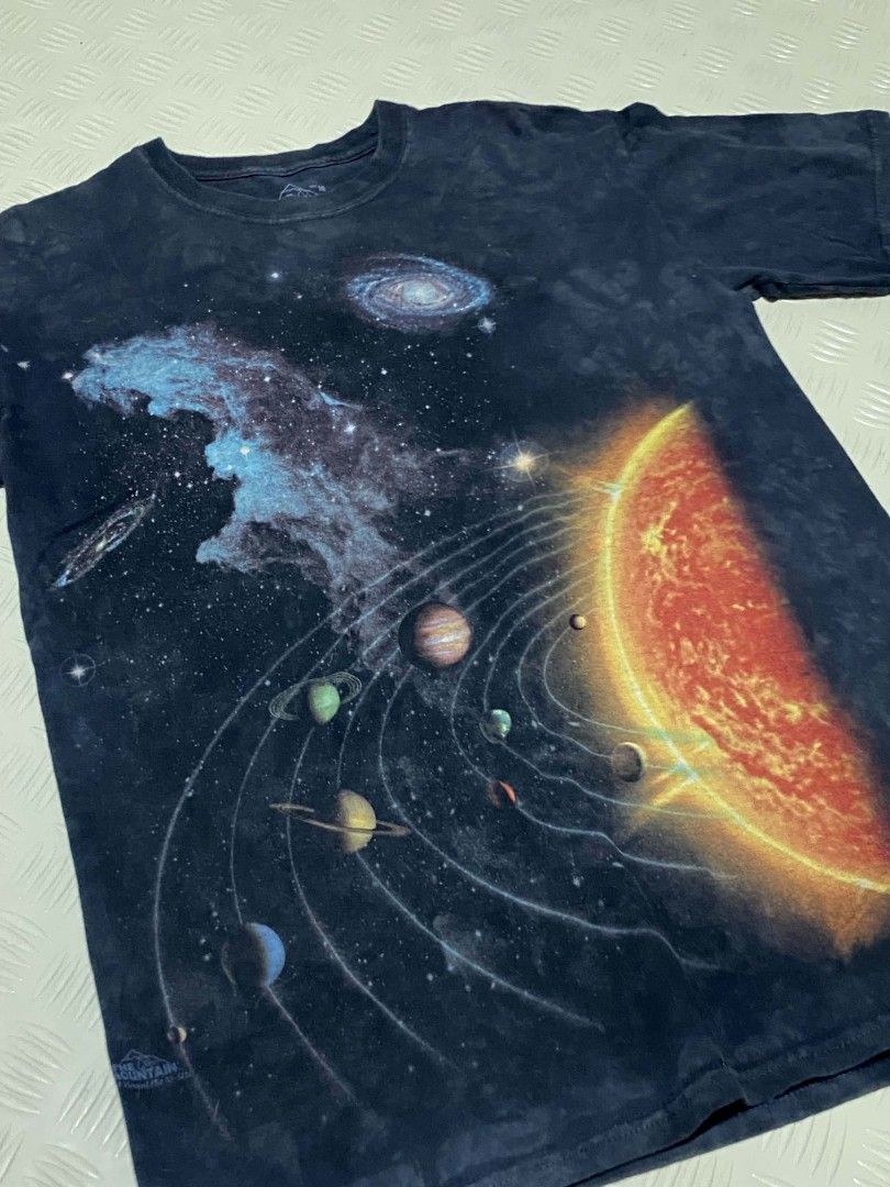 The Mountain Space Solar System T-Shirt Size M (Category: Tshirts & Polo Shirts ) located in Dipolog. Submitted by just_thriftfinds (Listing ID 1467846843, Image 2). Description: - Brand: The Mountain - Design: Solar system, planets, and galaxy graphic print - Artist/Copyright: Vincent Hie (Dated 2009 near hem) - Color/Pattern: Dark wash tie-dye - Size: Medium (Tag at collar) - Fit: Relaxed fit with regular short sleeves - Material: Comfortable 1