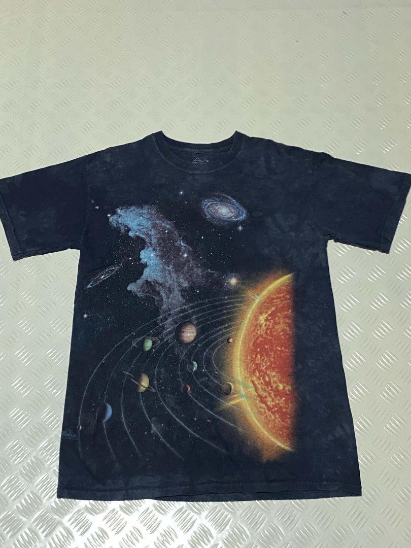 The Mountain Space Solar System T-Shirt Size M (Category: Tshirts & Polo Shirts ) located in Dipolog. Submitted by just_thriftfinds (Listing ID 1467846843, Image 1). Description: - Brand: The Mountain - Design: Solar system, planets, and galaxy graphic print - Artist/Copyright: Vincent Hie (Dated 2009 near hem) - Color/Pattern: Dark wash tie-dye - Size: Medium (Tag at collar) - Fit: Relaxed fit with regular short sleeves - Material: Comfortable 1
