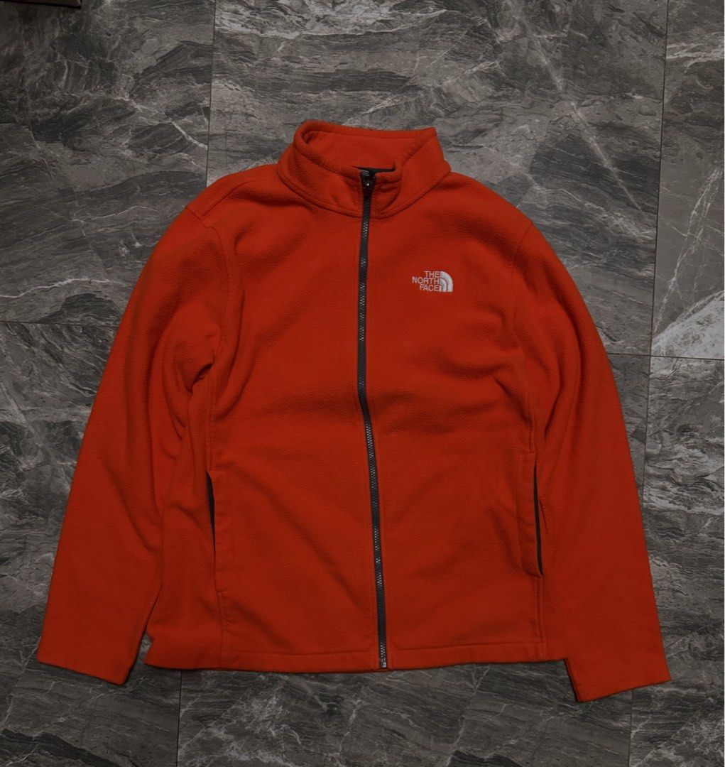 The North Face Orange Fleece Jacket Size L (Category: Coats, Jackets and Outerwear) located in Alaminos. Submitted by outfitcheck.ph (Listing ID 1467957877, Image 1). Description: - Brand: The North Face - Style: Full-zip fleece jacket with stand-up collar - Color: Bright orange - Size: Men's Large (L) - Origin: Made in Nicaragua - Features: Two side pockets, white embroidered logo on chest and back shoulder - Condition/Fabric: Soft, warm, and co
