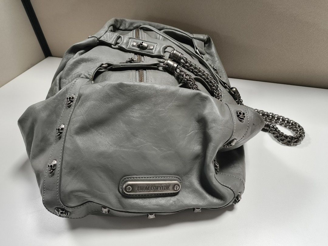Thomas Wylde Gray Leather Skull Chain Bag (Category: Luxury Bags & Wallets) located in Quezon City. Submitted by jdonor (Listing ID 1467848999, Image 1). Description: - Brand: Thomas Wylde - Material: Gray leather with normal wear (still solid condition) - Details: Edgy skull hardware on straps and bottom studs - Straps: Chunky metal chain shoulder strap - Closure: Top zipper closure - Interior: Cool skull print lining - Compartments: Roomy main 