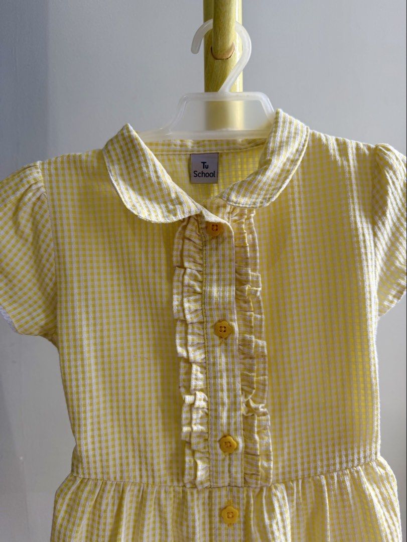 Tu School Yellow Gingham Dress (Category: Babies & Kids Fashion) located in Quezon City. Submitted by warmrabbit_414908 (Listing ID 1467876833, Image 3). Description: - Brand: Tu School - Color/Pattern: Bright yellow gingham - Material: Lightweight cotton with lining - Details: Classic collar, ruffled front placket, front buttons - Sleeves: Short cap sleeves with delicate lace trim - Fit: Attached waist tie belt in the back - Condition: Clean and