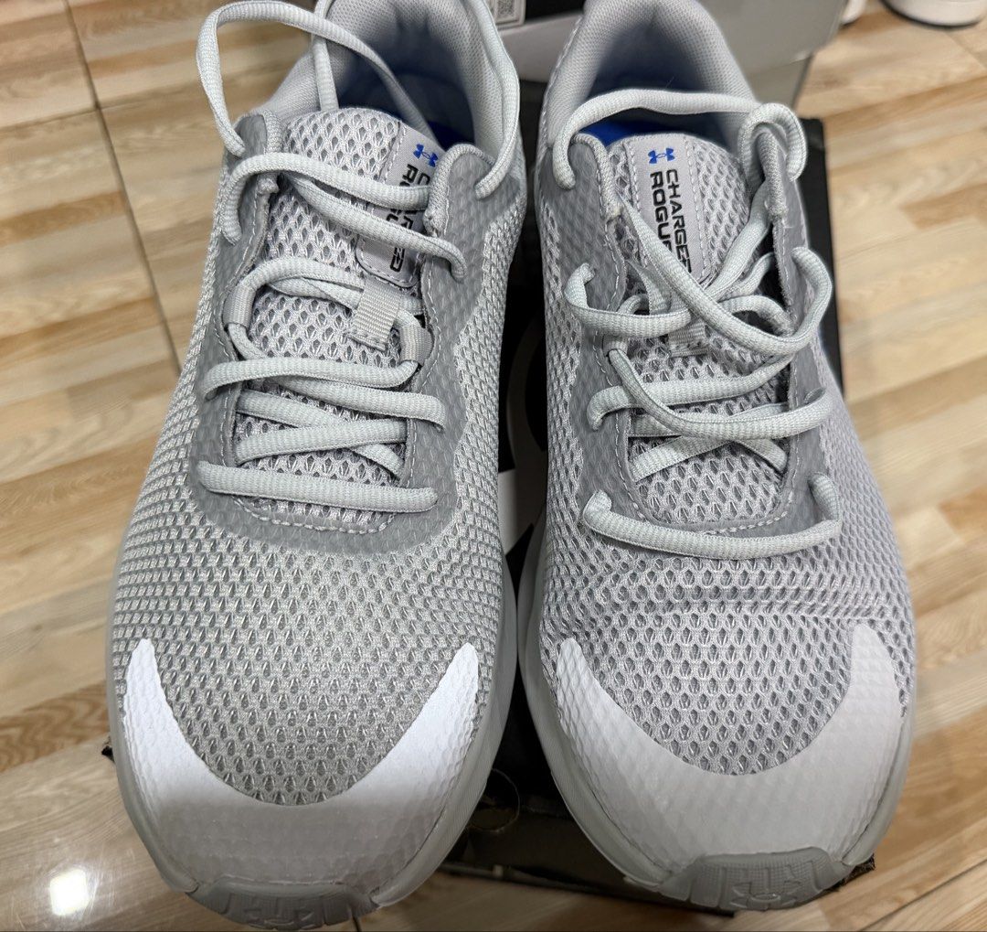 Under Armour UA Charged Rogue 3 Reflect Size 9.5 (Category: Sneakers) located in Tabuk. Submitted by farawayluxe (Listing ID 1468046189, Image 2). Description: - Brand: Under Armour Charged Rogue 3 Reflect - Color: Grey mesh upper with blue logo and white details - Size: US 9.5 - Condition: brand new - Comfort: Equipped with Deluxe Foam insoles - Inclusions: Original box included.