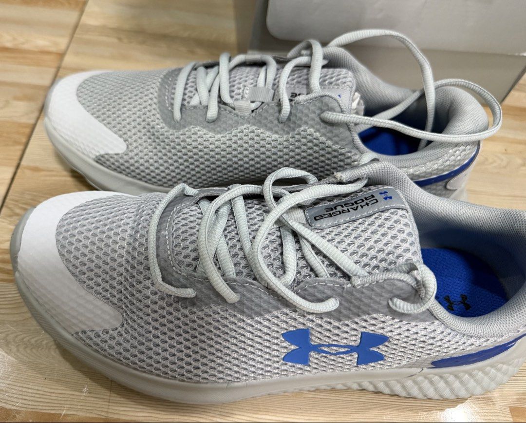 Under Armour UA Charged Rogue 3 Reflect Size 9.5 (Category: Sneakers) located in Tabuk. Submitted by farawayluxe (Listing ID 1468046189, Image 3). Description: - Brand: Under Armour Charged Rogue 3 Reflect - Color: Grey mesh upper with blue logo and white details - Size: US 9.5 - Condition: brand new - Comfort: Equipped with Deluxe Foam insoles - Inclusions: Original box included.