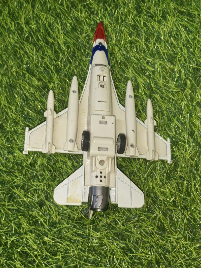 USAF Thunderbird Jet Fighter Toy Airplane (Category: Vehicle & Diecast Models) located in Paranaque City. Submitted by furugiyafinds (Listing ID 1467949662, Image 2). Description: - White plastic fighter jet toy with official USAF markings - Eye-catching red, white, and blue Thunderbird color scheme on nose, tail, and wings - Clear cockpit canopy with a visible pilot seat inside - Features attached missiles and drop tanks under the wings - Equipp