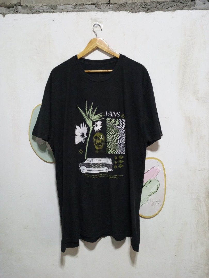 Vans Off the Wall Graphic Tee 2XL (Category: Tshirts & Polo Shirts ) located in Magdalena. Submitted by magdalenathrift20 (Listing ID 1467984613, Image 2). Description: - Brand: Vans - Style: Classic fit graphic t-shirt - Color: Black - Design: Bold front graphic with flowers, skull, and checkerboard pattern - Details: Small logo tag on left sleeve cuff - Material: 100% cotton - Size: XX-Large - Measurements (laid flat): Width 26.5 inches, Length