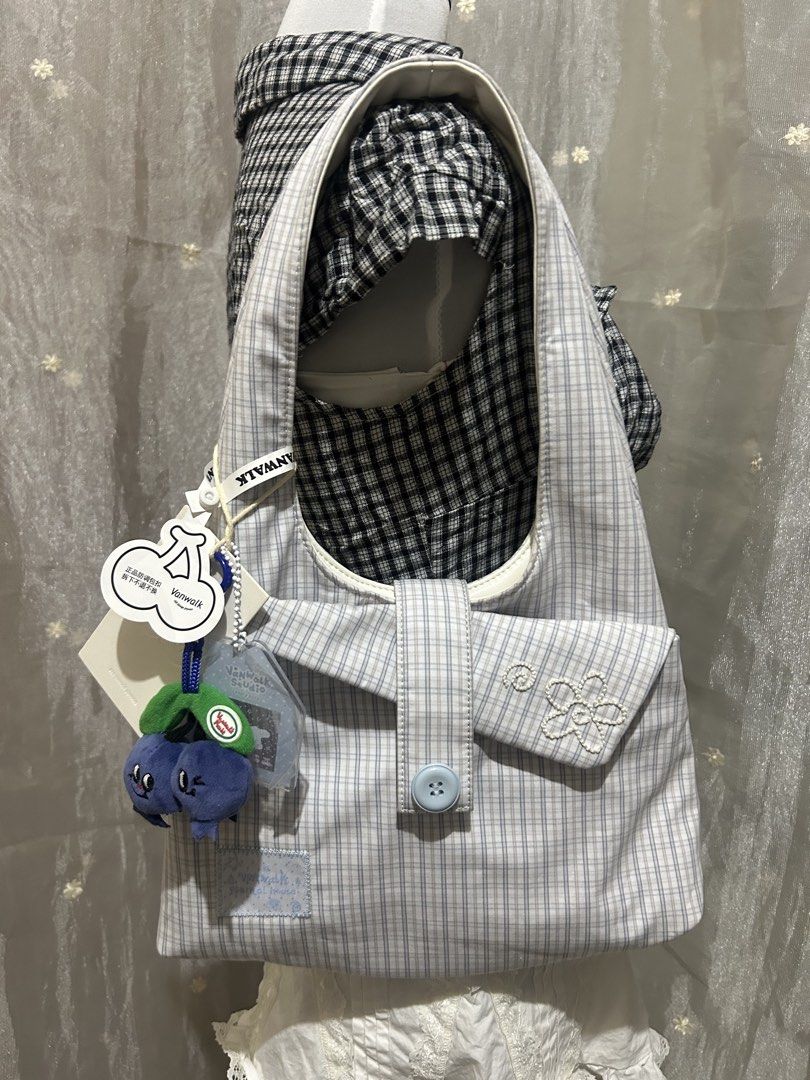 Vanwalk Reversible Plaid and White Shoulder Bag (Category: Shoulder Bags) located in Tuguegarao City. Submitted by eliwyxzs (Listing ID 1467841632, Image 1). Description: - Brand: Vanwalk - Style: Reversible shoulder bag - Side A: Blue and white plaid pattern with pocket and flower embroidery - Side B: Plain white with subtle embossed branding - Inclusions: Original tags attached + adorable blue berry plush charm - Features: Soft, comfortable sho
