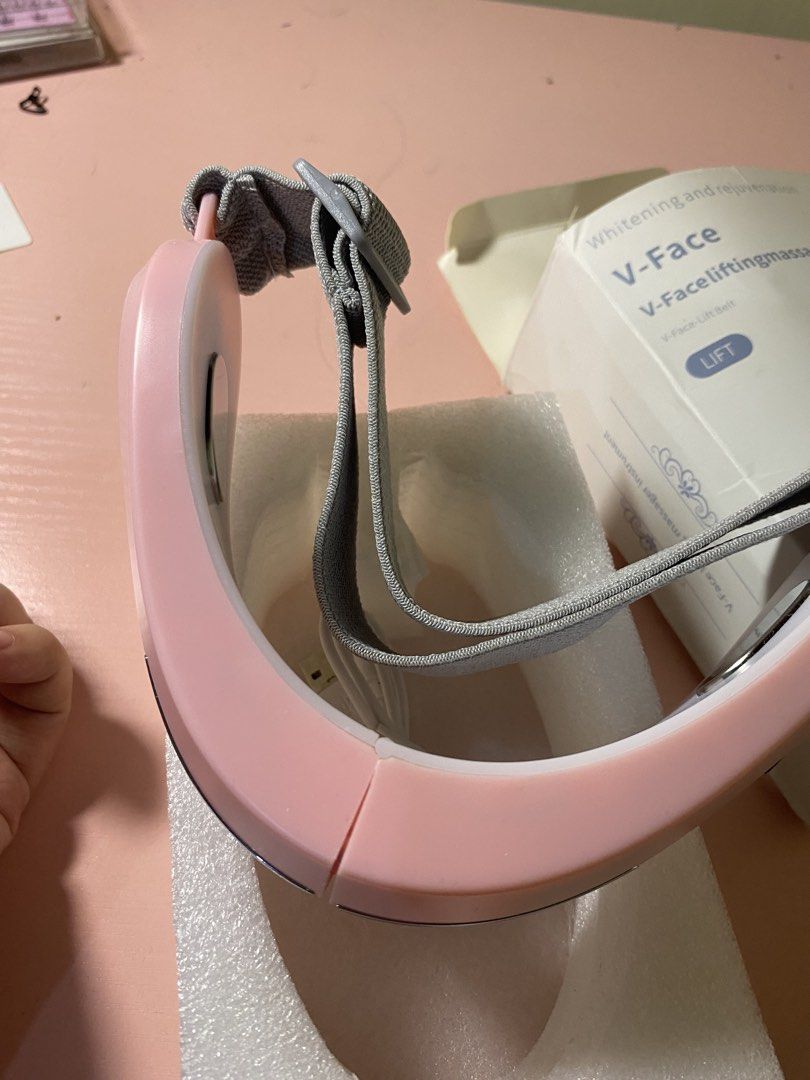 V-Face Face Lifting Massager Instrument (never used) (Category: Massage Devices) located in Manila. Submitted by deesdeclutter (Listing ID 1467948017, Image 3). Description: - Pink V-face lifting massager for skin rejuvenation and whitening - Adjustable grey elastic strap for a comfortable fit - Includes USB charging cable for easy power-ups - Comes in its original packaging box - Perfect addition to your daily skincare routine.