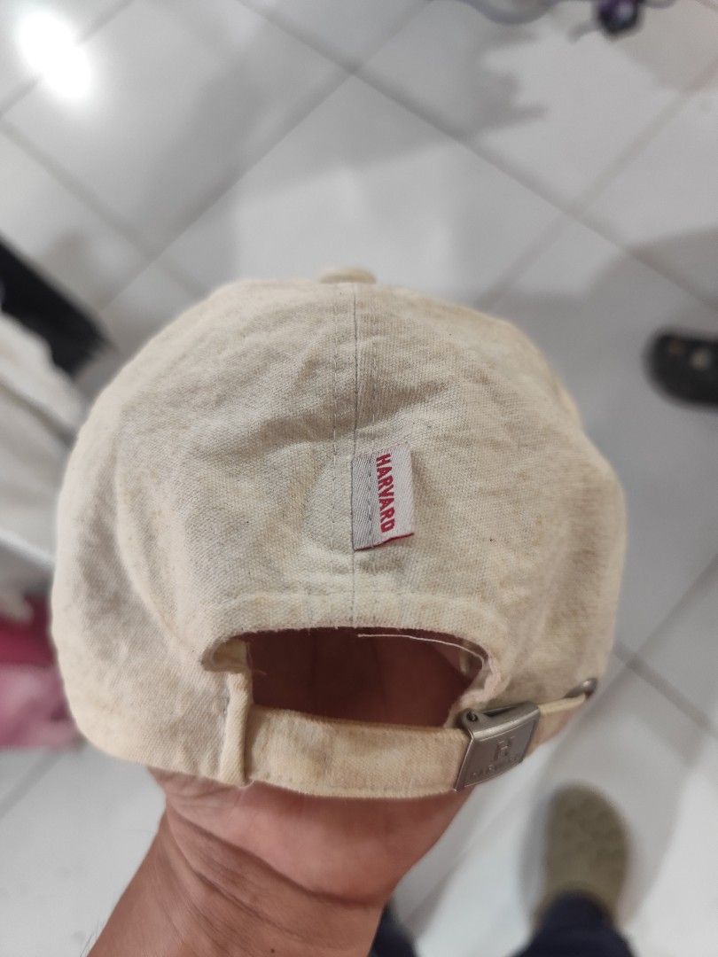 Vintage Harvard University Baseball Cap (Category: Caps & Hats) located in Cordova. Submitted by bsb.streetluxvintage.clothing (Listing ID 1467842183, Image 3). Description: - Authentic beige Harvard University baseball cap - Red and white embroidered lettering on the front - Small Harvard woven label at the back strap - Adjustable metal buckle closure with embossed logo - 100% cotton material with internal care tag - Flaws: Shows overall discolo