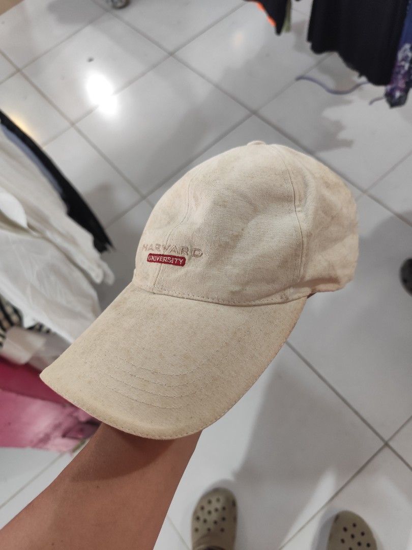 Vintage Harvard University Baseball Cap (Category: Caps & Hats) located in Cordova. Submitted by bsb.streetluxvintage.clothing (Listing ID 1467842183, Image 2). Description: - Authentic beige Harvard University baseball cap - Red and white embroidered lettering on the front - Small Harvard woven label at the back strap - Adjustable metal buckle closure with embossed logo - 100% cotton material with internal care tag - Flaws: Shows overall discolo