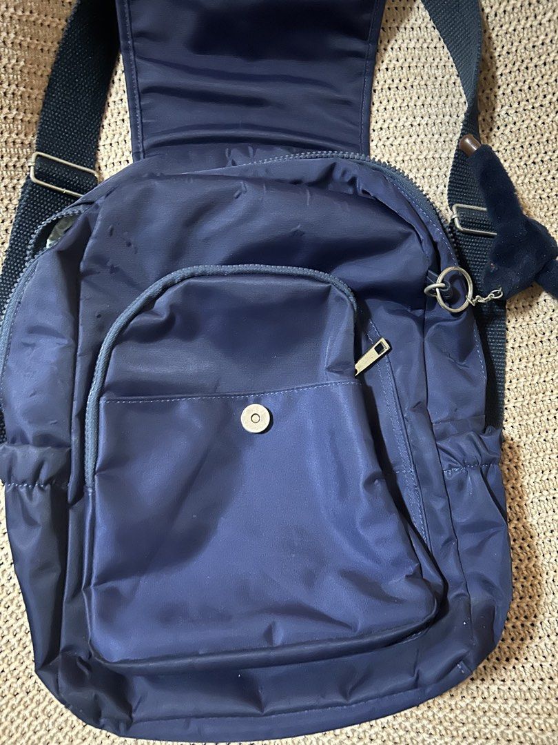 Vintage Kipling Navy Blue Backpack with Monkey Keychain (Category: Backpacks) located in Pasig City. Submitted by mixpicks (Listing ID 1467857509, Image 2). Description: - Color: Dark Blue - Material: Lightweight, durable nylon - Closure: main compartment with secure flap cover - Pockets: Front zippered pocket with snap flap cover and convenient side pockets - Comfort: Adjustable shoulder straps for a custom fit - Inclusion: Comes with the iconic