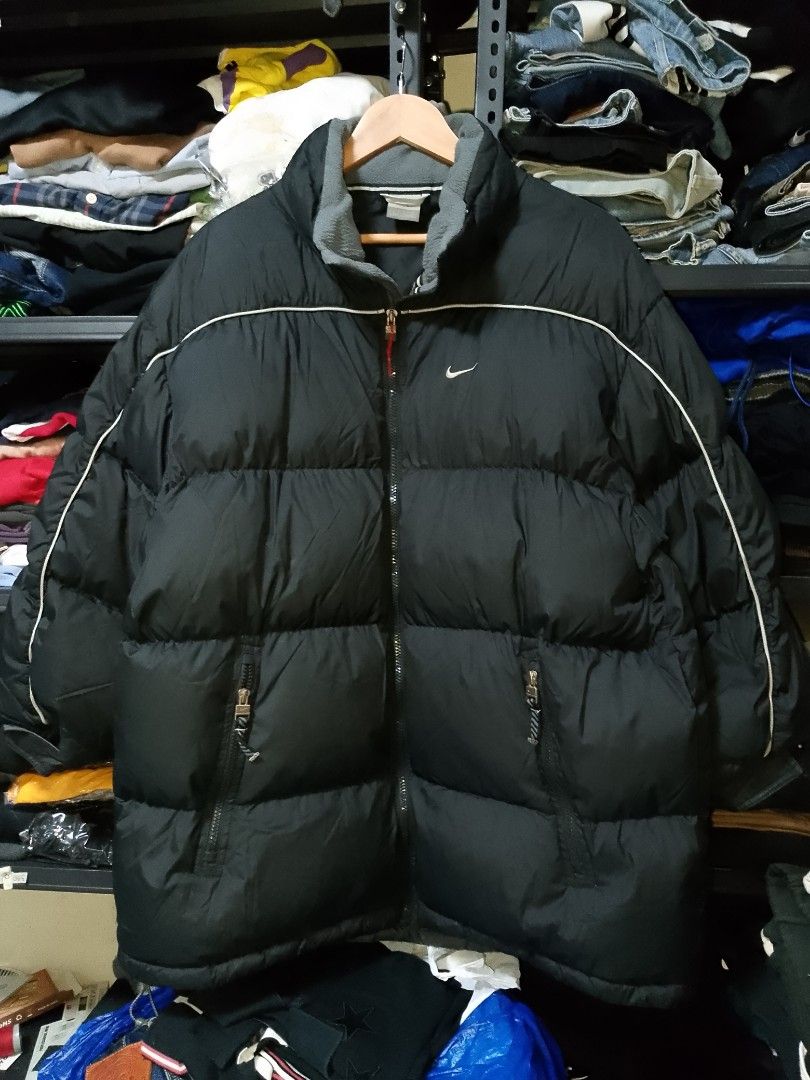Vintage Nike Black Puffer Jacket Size L (Category: Coats, Jackets and Outerwear) located in Manila. Submitted by mjthrifted_second (Listing ID 1467894412, Image 1). Description: - Brand: Nike -Dimes: 26/32 - Style: Puffer jacket with full zip front closure and branded zipper pulls - Color: Black with grey fleece inner collar and white piping details - Branding: Embroidered Nike swoosh logo on front and back - Size: L (Tag on collar) - Origin: Mad