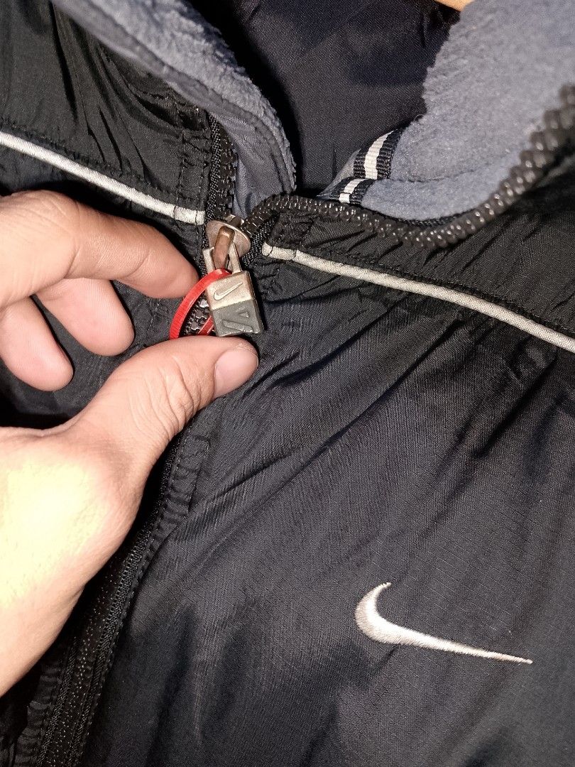 Vintage Nike Black Puffer Jacket Size L (Category: Coats, Jackets and Outerwear) located in Manila. Submitted by mjthrifted_second (Listing ID 1467894412, Image 3). Description: - Brand: Nike -Dimes: 26/32 - Style: Puffer jacket with full zip front closure and branded zipper pulls - Color: Black with grey fleece inner collar and white piping details - Branding: Embroidered Nike swoosh logo on front and back - Size: L (Tag on collar) - Origin: Mad