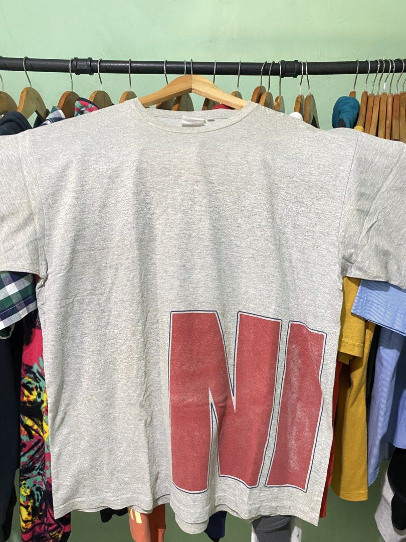 Vintage Nike Grey Graphic Tee Split Logo Front Back (Category: Tshirts & Polo Shirts ) located in Tiaong. Submitted by maticbuy (Listing ID 1467983330, Image 1). Description: - Brand: Nike - Color: Heather Grey - Size: Large - Design: Large red graphics on front bottom; large blue graphics with mini swoosh on back bottom - Fit: Relaxed fit with classic crew neck - Condition: Excellent casual wear piece .