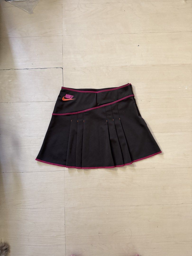 Vintage Nike Sport (Category: Skirts) located in Manila. Submitted by juhjuh (Listing ID 1467908229, Image 1). Description: - Brand: Nike - Style: Athletic skirt with pleated design and solid back panel - Color: Black with pink contrast stitching - Details: Orange and pink Nike logo on front waist - Size: S (tag attached) - Material: 100% polyester - Condition: Brand new / Excellent .