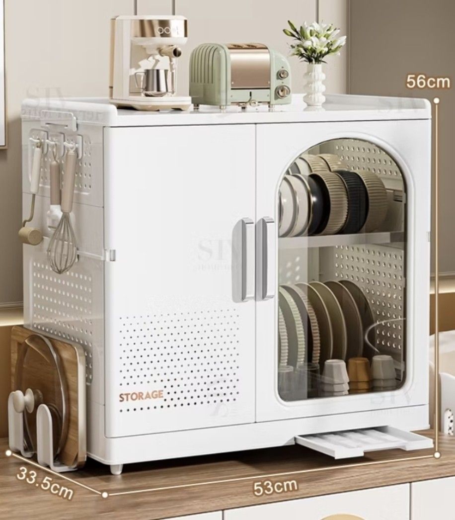 White Dish Organizer (Category: Shelves, Cabinets & Racks) located in Taguig. Submitted by apzdeclutter (Listing ID 1468026611, Image 3). Description: - Color: White - Material: Durable plastic - Dimensions: Approx. 53cm (W) x 56cm (H) - Features: - Two cabinet doors with a clear arched window on the right - Left side includes ventilation holes and hooks for utensils - Flat top surface ideal for small appliances or decor.