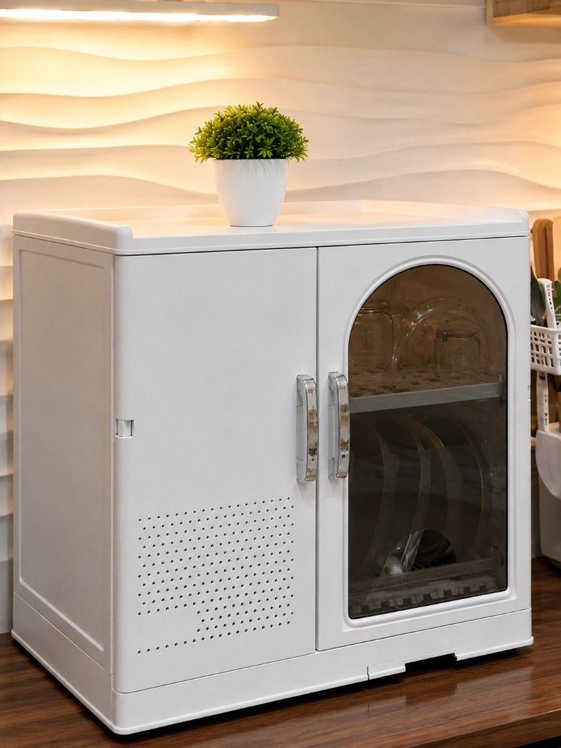 White Dish Organizer (Category: Shelves, Cabinets & Racks) located in Taguig. Submitted by apzdeclutter (Listing ID 1468026611, Image 1). Description: - Color: White - Material: Durable plastic - Dimensions: Approx. 53cm (W) x 56cm (H) - Features: - Two cabinet doors with a clear arched window on the right - Left side includes ventilation holes and hooks for utensils - Flat top surface ideal for small appliances or decor.