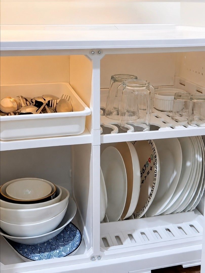 White Dish Organizer (Category: Shelves, Cabinets & Racks) located in Taguig. Submitted by apzdeclutter (Listing ID 1468026611, Image 2). Description: - Color: White - Material: Durable plastic - Dimensions: Approx. 53cm (W) x 56cm (H) - Features: - Two cabinet doors with a clear arched window on the right - Left side includes ventilation holes and hooks for utensils - Flat top surface ideal for small appliances or decor.