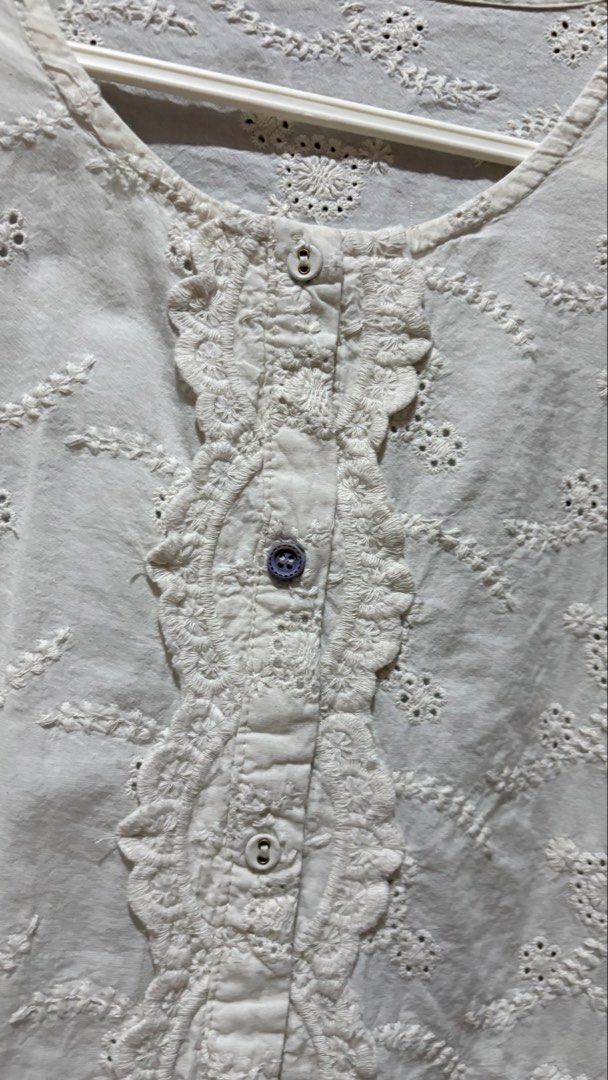 White Embroidered Button-Up Blouse with Ruffle Hem (Category: Blouses) located in Taytay. Submitted by sparklesandhighheels (Listing ID 1467885685, Image 2). Description: - Color: Classic white - Design: Intricate all-over embroidery with scalloped lace trim - Details: Round neckline, front button placket, and flounced ruffle hem - Fabric: Lightweight and breathable - Fit: Comfortable for warm weather and everyday wear.