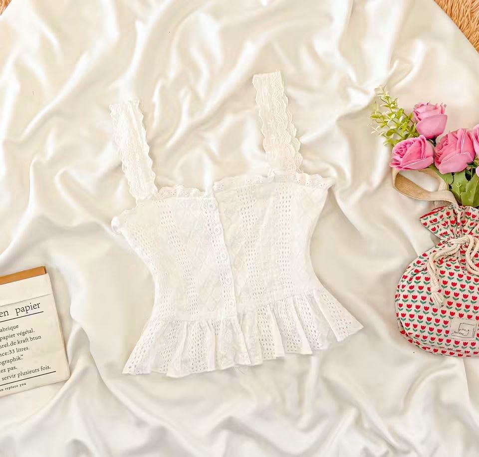 White Eyelet Peplum Cami Top (Category: Sleeveless) located in Manila. Submitted by preloved_tweeds_ph (Listing ID 1467948545, Image 1). Description: - Color: Clean white - Design: Wide straps, button-up front, and delicate floral embroidery - Fit: Flared peplum hem at the waist - Versatility: Great for warm weather or layering - Condition: Excellent, clean and well-maintained.