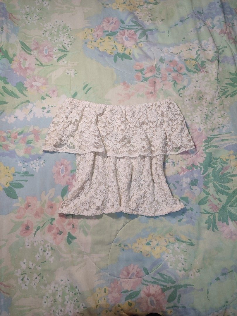White lace off-shoulder layered ruffle top (Category: Blouses) located in Jaen. Submitted by roxantiago (Listing ID 1468038350, Image 1). Description: - Color: Cream white - Material: Full floral lace (sheer, inner lining needed) - Design: Off-shoulder with a layered ruffle overlay at the chest - Fit: Stretchy elastic neckline for a secure fit - Styling: Great for pairing with denim shorts or skirts.