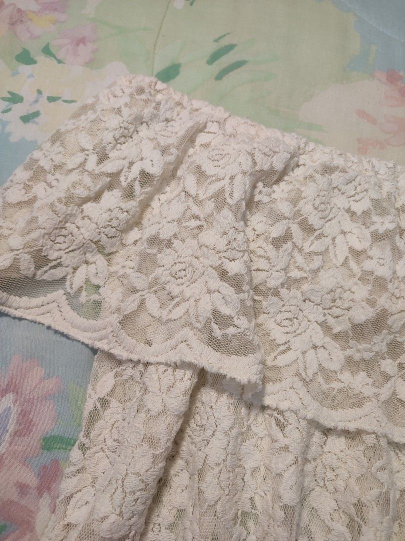 White lace off-shoulder layered ruffle top (Category: Blouses) located in Jaen. Submitted by roxantiago (Listing ID 1468038350, Image 3). Description: - Color: Cream white - Material: Full floral lace (sheer, inner lining needed) - Design: Off-shoulder with a layered ruffle overlay at the chest - Fit: Stretchy elastic neckline for a secure fit - Styling: Great for pairing with denim shorts or skirts.