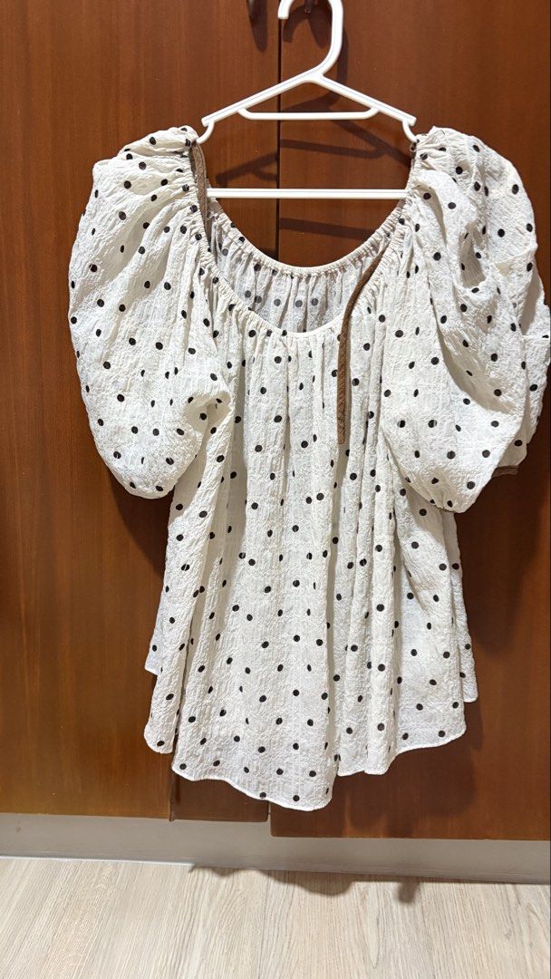 White Polka Dot Puff Sleeve Blouse (Category: Blouses) located in Taytay. Submitted by sparklesandhighheels (Listing ID 1467886314, Image 1). Description: - Color & Pattern: White with black polka dots - Design: Square neckline, big puffy sleeves, and all-over gathered texture - Material: Light, breathable, and flowy fabric - Extra Feature: Comes with a thin brown strap attached inside - Styling: Casual piece, easy to match with jeans or skirts.