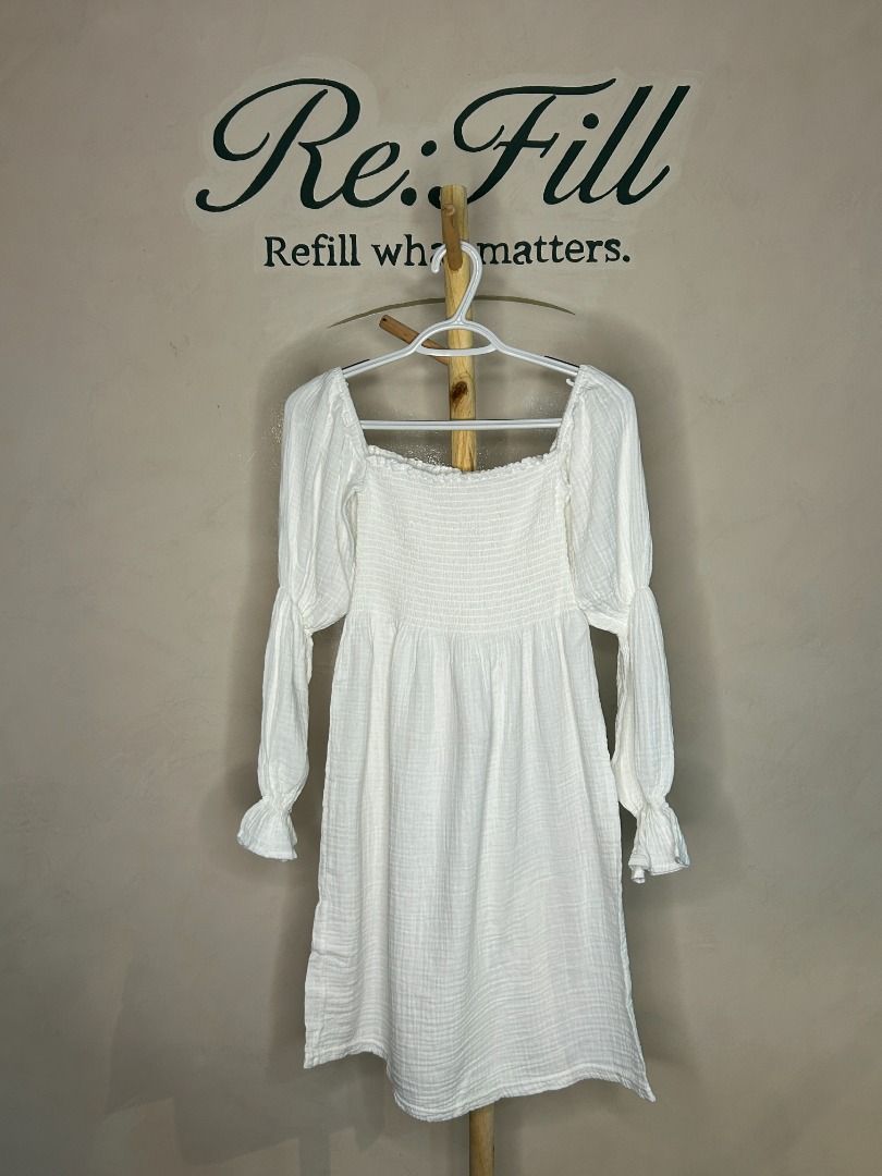 White Square Neck Long Sleeve Dress (Category: Dresses) located in Taguig. Submitted by re.wear.mnl (Listing ID 1468008355, Image 1). Description: - Color: White - Style: Mini dress with square neckline and flowy skirt - Details: Long sleeves with ruffled cuffs, heavily smocked bodice, and textured crinkle finish - Material: Lightweight cotton gauze (pullover style) - Versatility: Great for casual days out, weekend brunches; pairs well with flats
