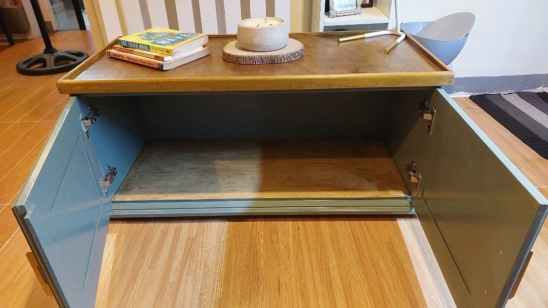 Wooden Coffee Table with Cabinet and Storage Space (Category: Tables & Sets) located in Caloocan City. Submitted by eleven.thirty (Listing ID 1467861318, Image 2). Description: Newly Refurbished Console cabinet for Sale - Warm brown wooden top with raised edges - Dual green-gray door storage cabinet with new gold-toned handles - Clean interior shelf for everyday clutter - Sturdy and solid build - Perfect blend of style and function for your livin