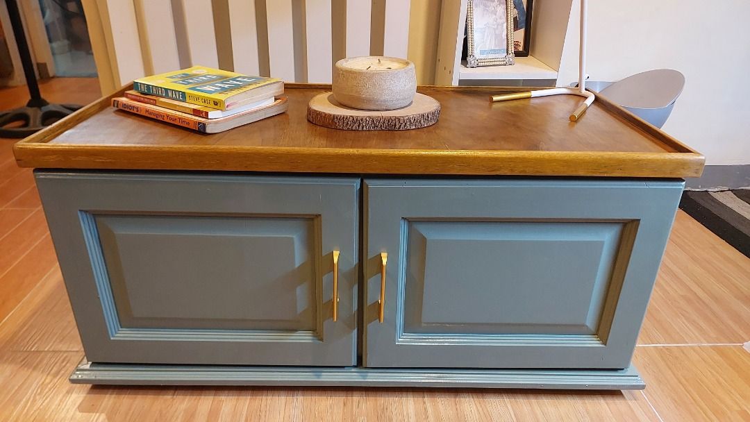 Wooden Coffee Table with Cabinet and Storage Space (Category: Tables & Sets) located in Caloocan City. Submitted by eleven.thirty (Listing ID 1467861318, Image 1). Description: Newly Refurbished Console cabinet for Sale - Warm brown wooden top with raised edges - Dual green-gray door storage cabinet with new gold-toned handles - Clean interior shelf for everyday clutter - Sturdy and solid build - Perfect blend of style and function for your livin