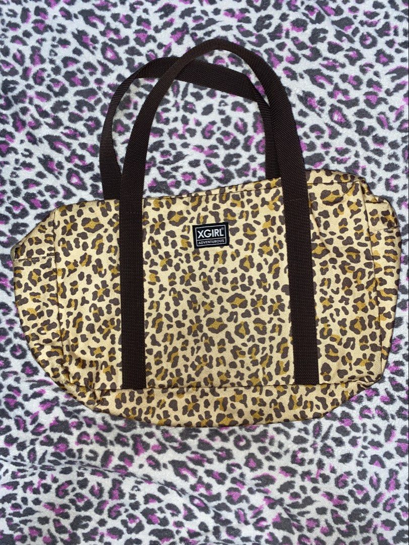 X-Girl Leopard Print Boston Bag (Category: Tote Bags) located in Calamba. Submitted by 3n.rique (Listing ID 1467924407, Image 1). Description: - Brand: X-Girl - Design: Fuzzy leopard print with brown fabric handles and front brand patch - Features: Roomy interior, ideal for daily essentials - Condition: Great everyday shoulder bag with a small greenish stain near the bottom corner.