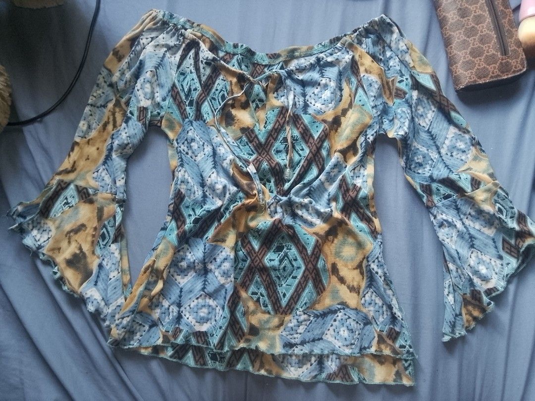 Y2k fairy boho bell sleeve top (Category: Longsleeves) located in Adams. Submitted by yelri888 (Listing ID 1467920019, Image 2). Description: Y2K Boho Bell Sleeve Top Size: S to M (stretchy) Style: Off-shoulder, tie front with beads, bell sleeves Color: Blue / Teal / Brown Aztec print Fabric: Soft stretch, with inner lining - not see-through Condition: 9/10 - no butas, good pa Location: Narvacan, Ilocos Sur MOP: GCash.