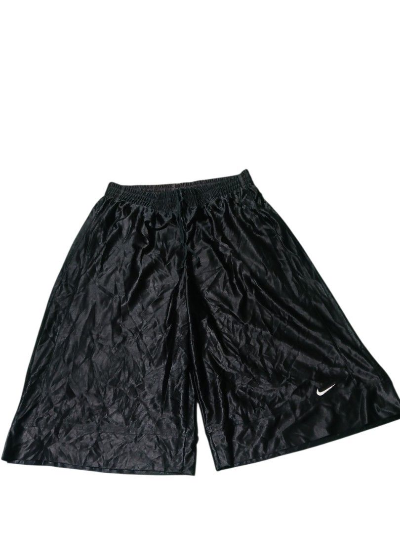 Y2k Nike shiny baller short (Category: Shorts) located in San Jose. Submitted by garments17 (Listing ID 1467970007, Image 1). Description: - Color: Sleek black with a glossy satin-like finish - Branding: Nike swoosh on the lower left leg and basketball graphic near the back waistband - Technology: Dri-FIT fabric keeps you dry and cool during workouts - Fit: Elastic waistband with adjustable drawstring for a secure fit - Comfort: Loose, wide-leg c