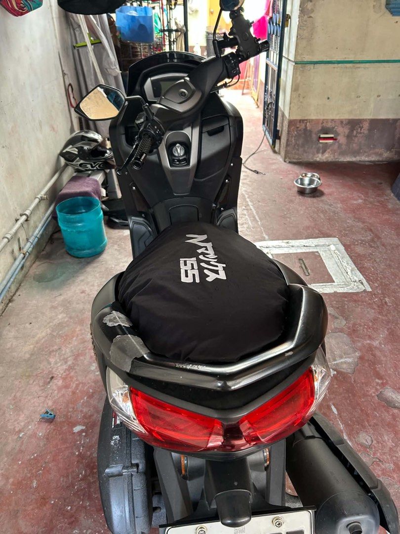 Yamaha NMAX Version 2 (Category: Motorbikes for Sale) located in Manila. Submitted by kiersten2792 (Listing ID 1467883456, Image 2). Description: Yamaha NMAX 155 scooter in black finish. Gold wheels and front disc brake setup. Windshield has several club and fuel stickers applied. Seat has a black protective cover with NMAX 155 branding. Handlebars include mirrors and Yamaha grip. Side plastics show light dust and minor wear from everyday riding.