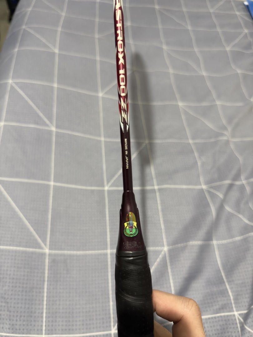 Yonex Astrox 100 ZZ Badminton Racket (Category: Racket and Ball Sports) located in Los Banos. Submitted by bancolitaalfred (Listing ID 1468028066, Image 3). Description: - Model: Yonex Astrox 100 ZZ - Origin: Made in Japan - Design: Dark red and multi-coloured frame with striking turquoise accents.
