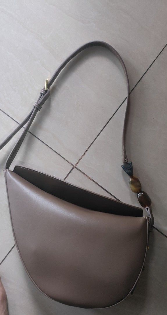 ZARA Brown Shoulder Bag with Resin Bead Strap (Category: Shoulder Bags) located in Caloocan City. Submitted by joshuadyogi0122 (Listing ID 1467844494, Image 1). Description: - Brand: ZARA - Color: Brown - Shape: Trendy semi-circle with flap closure - Strap: Adjustable strap detailed with tortoiseshell resin beads - Interior: Clean lining with official INDITEX group branding and style reference tag - Capacity: Compact yet roomy enough for daily es
