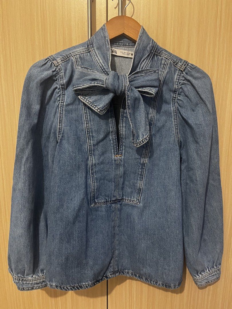 Zara denim bow neck blouse size S (Category: Blouses) located in Manila. Submitted by lorenasant37621 (Listing ID 1467931481, Image 2). Description: - Brand: Zara - Style: Denim blouse with tie-neck bow detail - Color: Medium wash blue - Details: Long sleeves, gathered shoulders, buttoned cuffs, front button placket - Size: EUR S, USA S, MEX 26 - Origin: Made in Turkey - Condition: Great casual top.