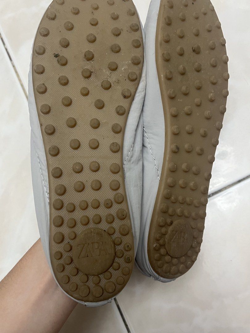 Zara Grey Slip-On Sneaker Mules (Category: Flats & Sandals) located in Quezon City. Submitted by sunday.closet (Listing ID 1467942822, Image 3). Description: - SIZE 36 - Style: Grey slip-on mules - Details: Puffer-style upper with lace detailing and suede-like toe cap - Sole: Rubber pebble sole with embossed Zara logo at the heel - Condition: Decent shape, clean insoles, and minor dirt marks on the bottom soles from normal wear - Perfect for: Eas