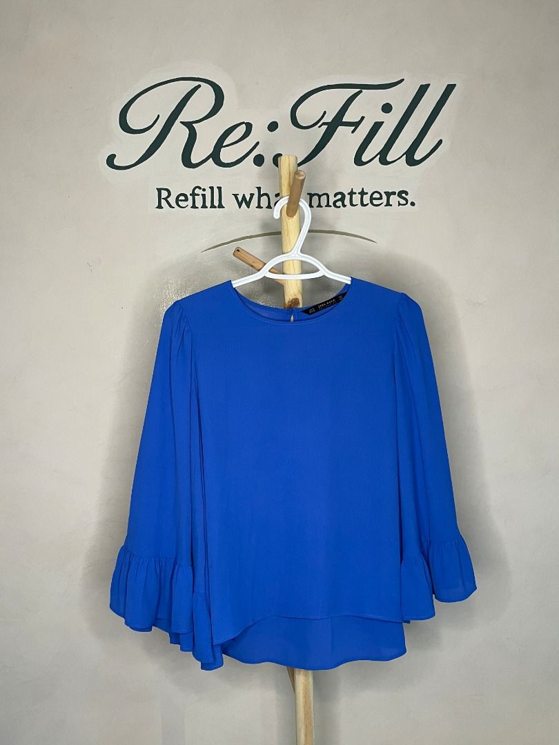 Zara Royal Blue Long Sleeve Blouse (Category: Longsleeves) located in Taguig. Submitted by re.wear.mnl (Listing ID 1468006857, Image 1). Description: - Brand: Zara - Color: Bright Royal Blue - Size / Fit: Round neckline with shoulder gathers and flared bell sleeves - Material: 100% lightweight polyester (Made in Turkey) - Condition: Clean, excellent overall condition with no stains or holes - Style: Versatile piece, great for work or casual wear.