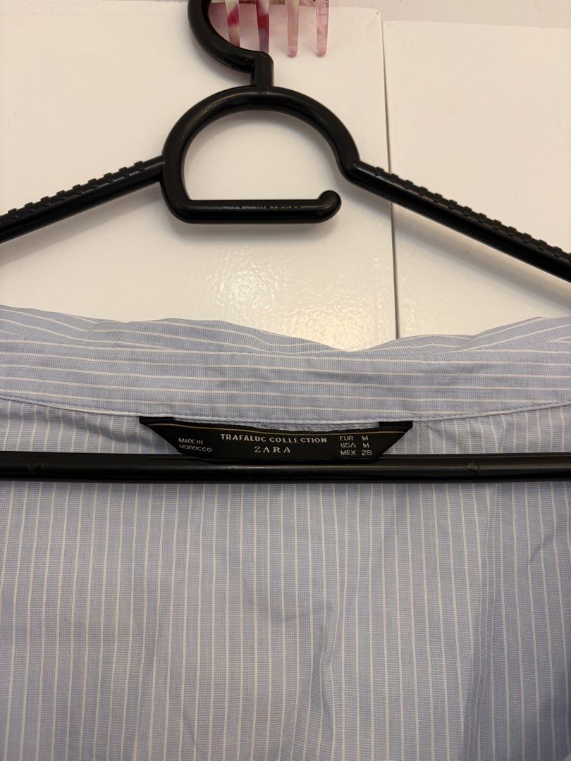 Zara Striped Off Shoulder Button Down (Category: Blouses) located in Quezon City. Submitted by prelovedbynxkole (Listing ID 1467884838, Image 2). Description: - Brand: Zara Trafaluc Collection - Design: Light blue and white vertical stripes - Fit: Oversized with trendy off-the-shoulder foldover collar - Details: Long sleeves with wide buttoned cuffs - Size: M - Origin: Made in Morocco - Style: Versatile; easy to dress up or wear casually ALL CLOT