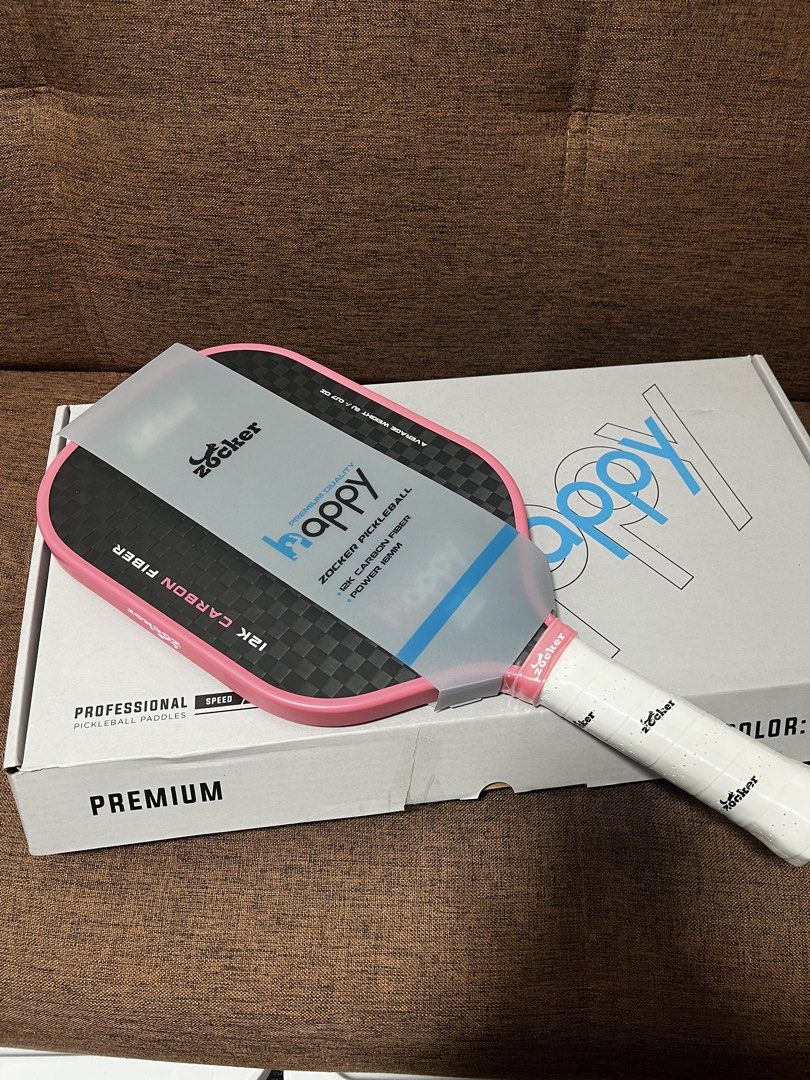 Zocker Happy Hypercontrol 12K Carbon Fiber Pickleball Paddle (Category: Racket and Ball Sports) located in Manila. Submitted by thefootyhub (Listing ID 1467919007, Image 1). Description: NEGOTIABLE Zocker Happy Hypercontrol pickleball paddle. 12K carbon fiber face, power 16mm thickness, PP and EVA honeycomb core. Average weight around 8.1 oz. Pink trim with white perforated grip tape featuring printed brand logos. Includes original box..