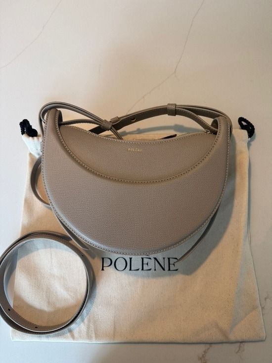 💜 Polene Numéro DixEdition Textured Taupe Bsg (Category: Luxury Bags & Wallets) located in Lala. Submitted by mohsin0825 (Listing ID 1468282455, Image 1). Description: Polene Numéro DixEdition Textured Taupe Bag 13,990p plus sf - Color: Textured Taupe - Design: Trendy crescent / half-moon shape with structured paneling - Versatility: Adjustable strap for comfortable shoulder or crossbody styling - Material: Premium textured finish with clean sti