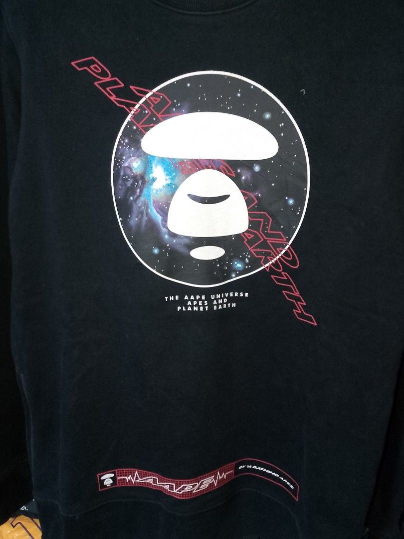 AAPE By A Bathing Ape Universe Space Sweatshirt (Category: Coats, Jackets and Outerwear) located in Manila. Submitted by mjthrifted_second (Listing ID 1468091090, Image 2). Description: - Brand: AAPE by A Bathing Ape - Color: Classic Black -Dimes: 21/28 - Design: Large galaxy graphic with Ape head logo on front, accented with red 'APUNVS' and 'Planet Earth' text - Details: Small branding near the back collar and bold red text near the back hem - 