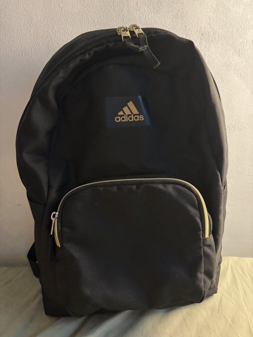 Adidas Black Gold Logo Backpack (Category: Backpacks) located in Manila. Submitted by ajdeclutter (Listing ID 1468192571, Image 1). Description: - Brand: Adidas - Color: Black with chic gold branding and hardware - Storage: Roomy main compartment with inner slip pocket and front zippered pocket - Material: 100% recycled polyester with wipe-clean interior -bought in the US - used once, not even for a full day.