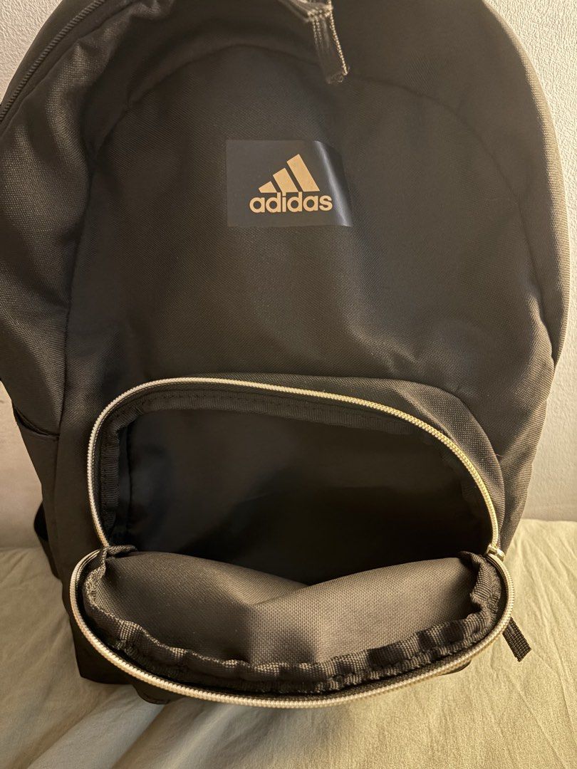 Adidas Black Gold Logo Backpack (Category: Backpacks) located in Manila. Submitted by ajdeclutter (Listing ID 1468192571, Image 2). Description: - Brand: Adidas - Color: Black with chic gold branding and hardware - Storage: Roomy main compartment with inner slip pocket and front zippered pocket - Material: 100% recycled polyester with wipe-clean interior -bought in the US - used once, not even for a full day.