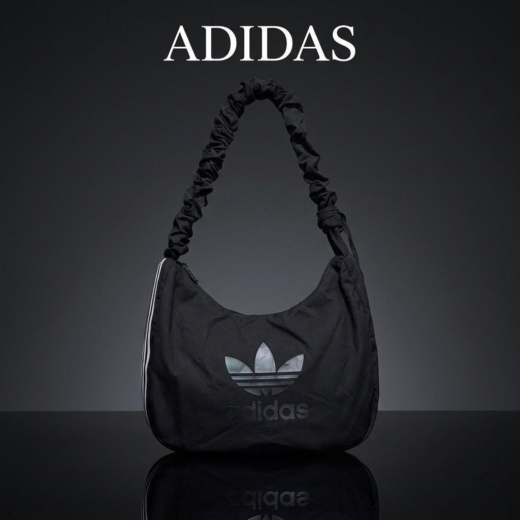 Adidas Black Shoulder Bag Hobo Bag (Category: Shoulder Bags) located in Carmen. Submitted by ar_thrift00 (Listing ID 1468282600, Image 1). Description: - Brand: Adidas - Color: Classic Black - Design: Large Trefoil logo on front - Strap: Trendy gathered scrunch strap - Closure: Zip closure with branded metal pull - Details: Inner slip tag with barcode and Adidas branding - Material: Lightweight fabric body.