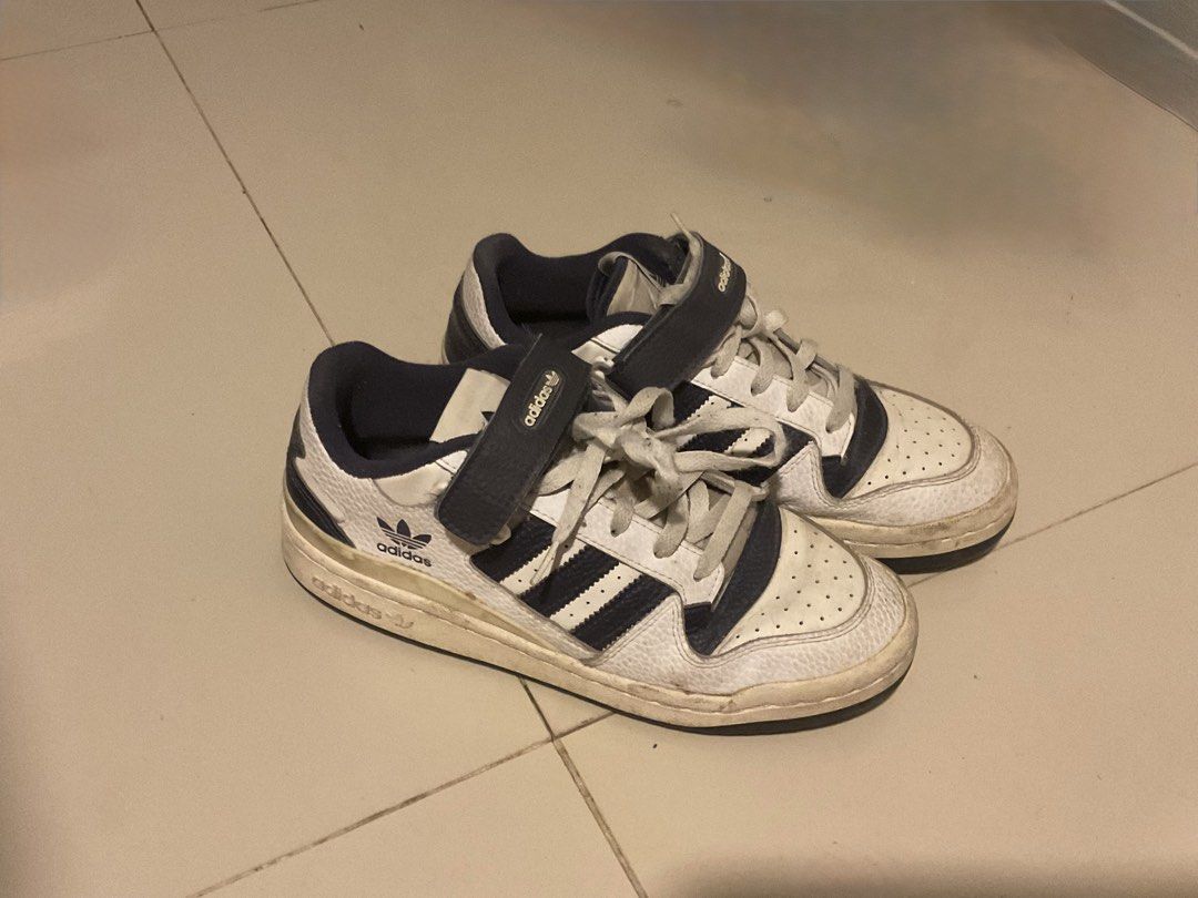 Adidas Forum Low White Navy Sneakers (Category: Sneakers) located in Cebu City. Submitted by sof09 (Listing ID 1468103200, Image 1). Description: - Brand/Model: Adidas Forum Low - Colorway: White and Navy Blue - Style: Retro basketball sneakers with ankle strap and laces - Material: Leather upper with breathable toe box perforation - Branding: Iconic Trefoil logo on side and tongue - Condition: Pre-loved with visible sole wear and natural yellowi