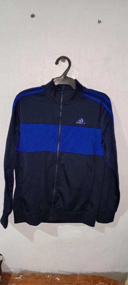 Adidas Navy Blue and Royal Blue Track Jacket (Category: Coats, Jackets and Outerwear) located in Manila. Submitted by ezekislacl02490 (Listing ID 1468282988, Image 2). Description: - Authentic Adidas track jacket - Color: Navy blue and royal blue with distinct horizontal chest block - Design: Classic three stripes on shoulders/sleeves, embroidered logo on right chest - Features: Full zip closure, high collar, ribbed cuffs and hem - Condition: Exc