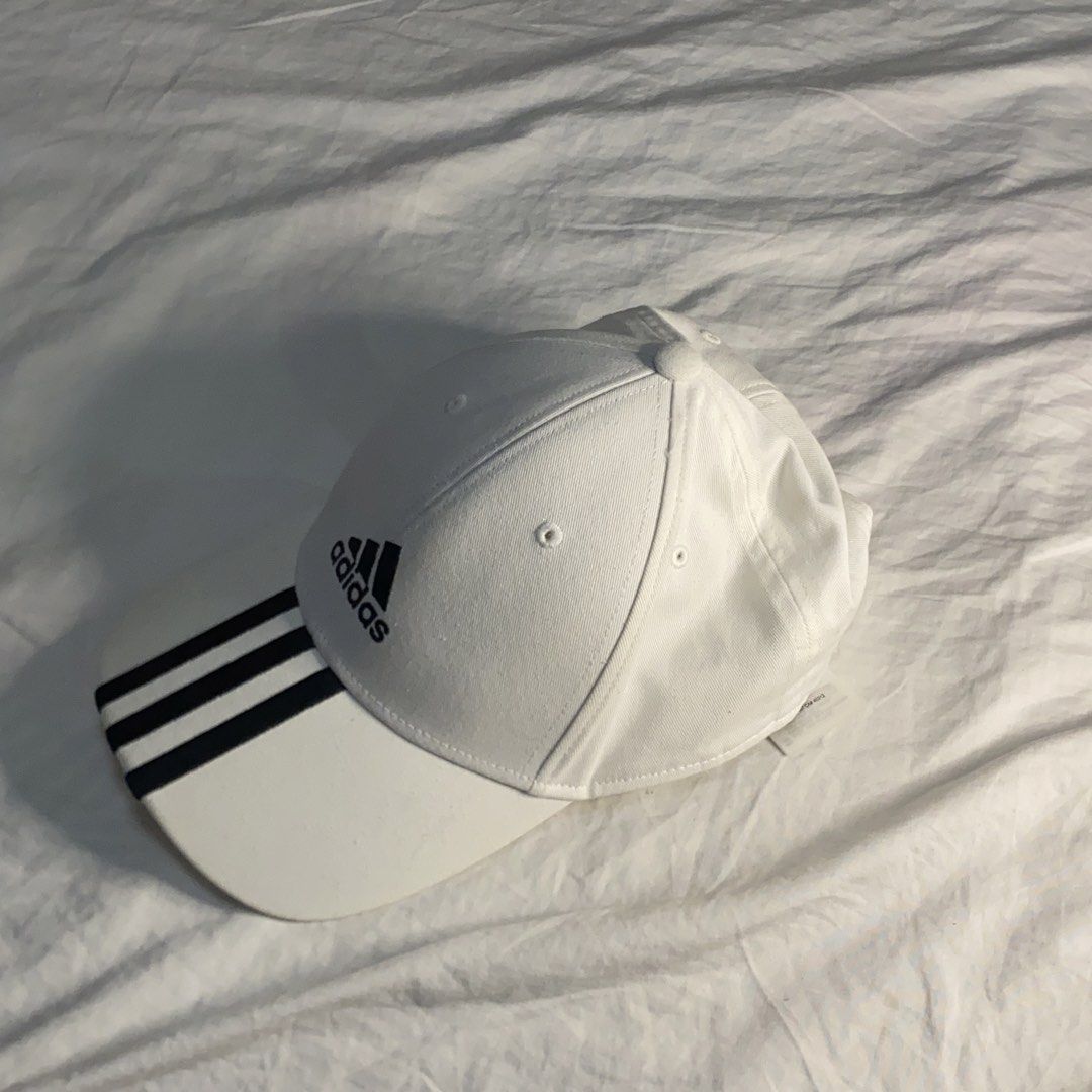 Adidas White Cap with Black Stripes (Category: Caps & Hats) located in Quezon City. Submitted by suzue.xen (Listing ID 1468100098, Image 1). Description: - Brand: Adidas - Color: Classic White with Black Accents - Design: Iconic 3-stripes on the curved brim with embroidered front logo - Ventilation: Metal eyelets on top for breathability - Fit: Adjustable strapback closure for a custom fit - Condition: Clean, ready to wear - Style: Great for spor