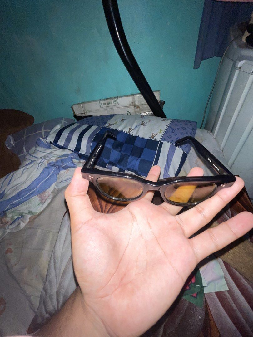 AKILA Legacy Sunglasses with Cork Case (Category: Sunglasses & Eyewear) located in Caloocan City. Submitted by shingshing16 (Listing ID 1468067906, Image 2). Description: - Brand/Model: AKILA Legacy sunglasses - Frame/Lenses: Black frames with tinted amber-yellow lenses - Details: Engraved inner arms reading 'AKILA' and 'AS A REALIZATION PROCESS' - Condition: Clean lenses and sturdy hinges - Inclusions: Original branded cork storage case.
