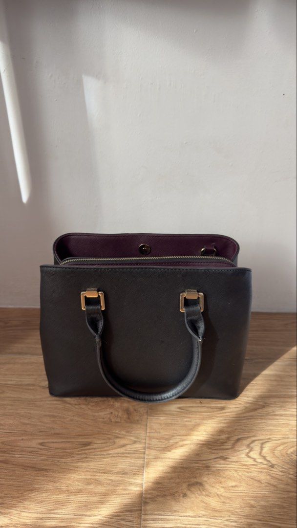 Aldo Black and Maroon Structured Tote Handbag (Category: Tote Bags) located in Lipa City. Submitted by eden.cheexe (Listing ID 1468283036, Image 2). Description: - Brand: Aldo - Color: Classic black exterior with a stylish maroon interior - Hardware: Gold-tone accents and front logo branding - Extras: Removable gold padlock and chain charm included - Compartments: Center zipped compartment with open sections and magnetic closure - Organization: M